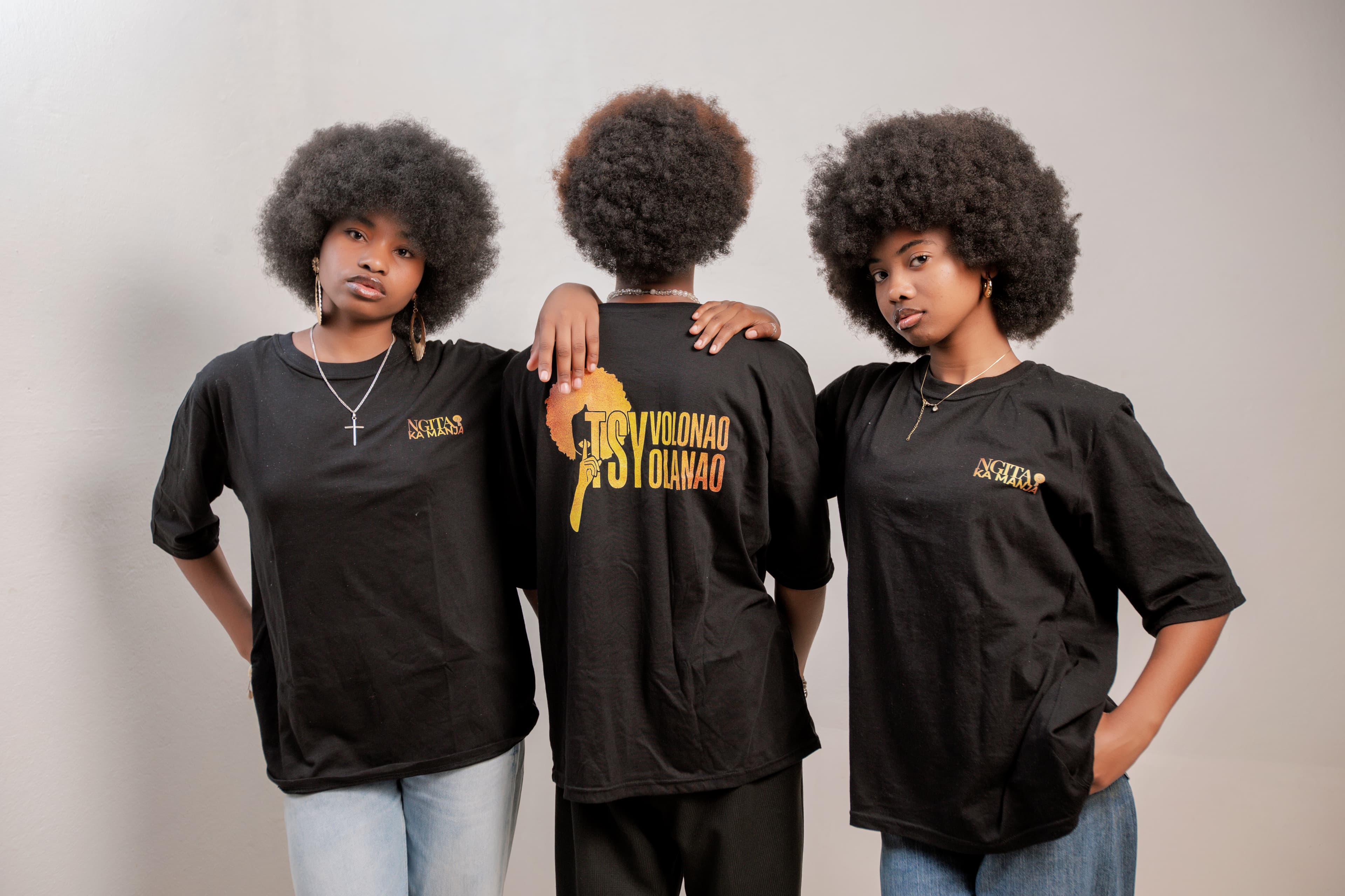 Paulah, Joel et Abelinah côte à côte, face et dos du t-shirt
